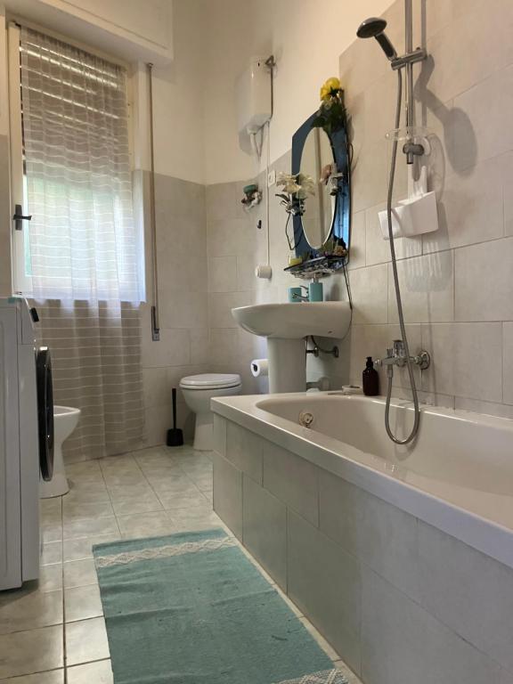 een badkamer met een bad, een wastafel en een toilet bij La melanetta in Noli