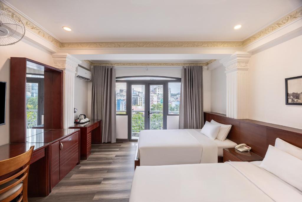 a hotel room with two beds and a television at A25 Hotel - 167 Phạm Ngũ Lão in Ho Chi Minh City