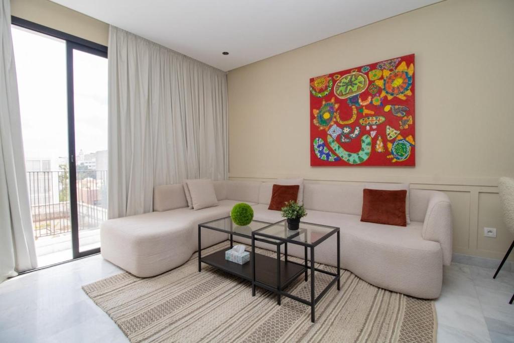 a living room with a couch and a painting on the wall at Beautiful Studio in Oasis - Gym access & Balcony & Free Parking & Wifi Fiber in Casablanca