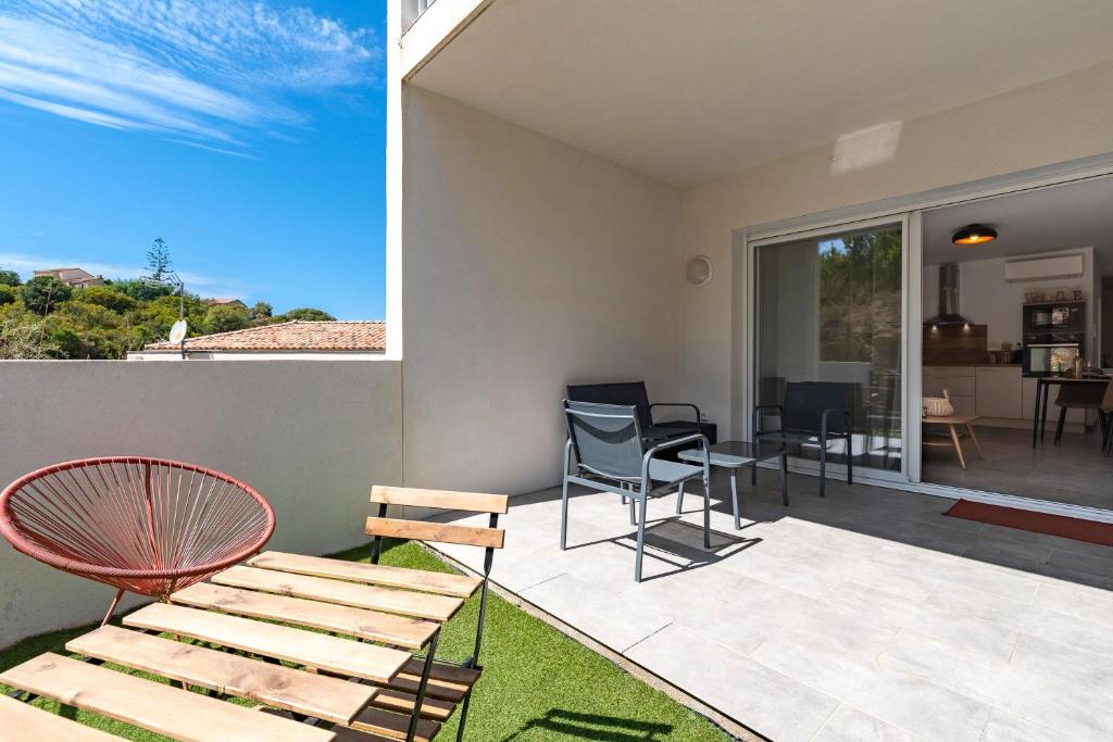 una camera con patio arredato con sedie e tavolo di L'Île de Beauté - Climatisé a Agnarelu