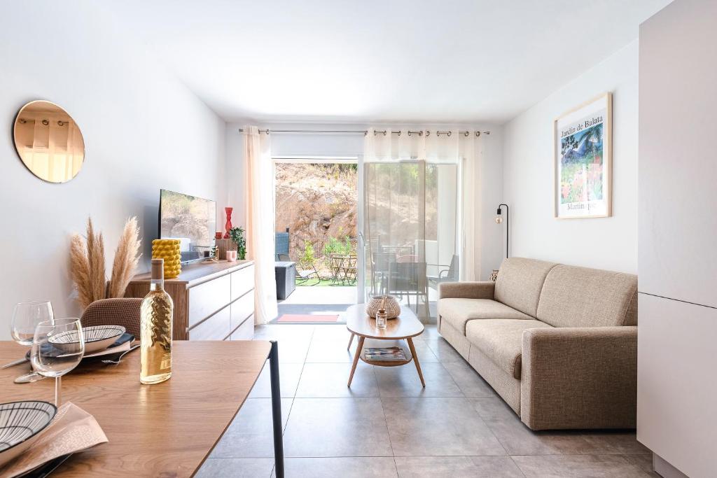 a living room with a couch and a table at L'Île de Beauté - Climatisé in Pietrosella