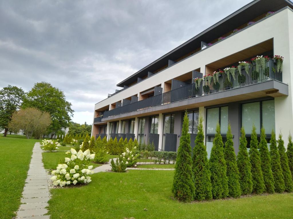 a building with a balcony with plants and flowers at Albatross Apartment Sea in Ķesterciems