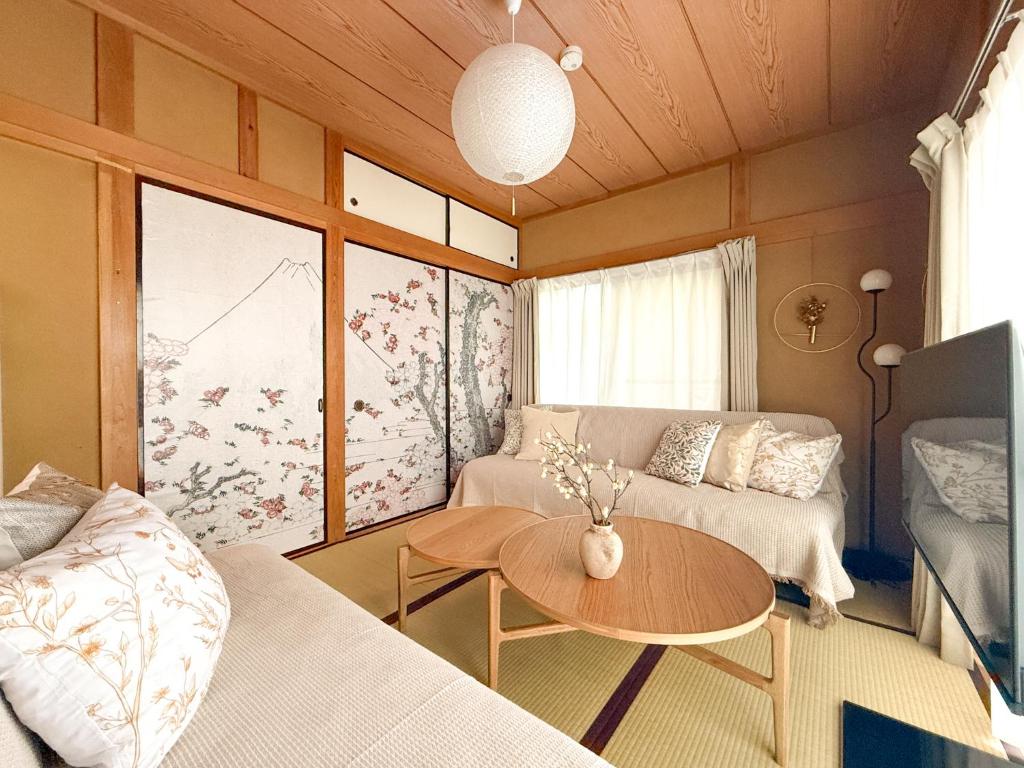 una sala de estar con un sofá y una mesa en 春花秋月 -Shunkashugetsu-, en Kawasaki