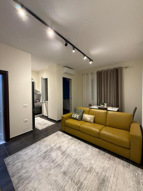 a living room with a yellow couch and a kitchen at Oasis Bay Lalzi in Lalzit Bay