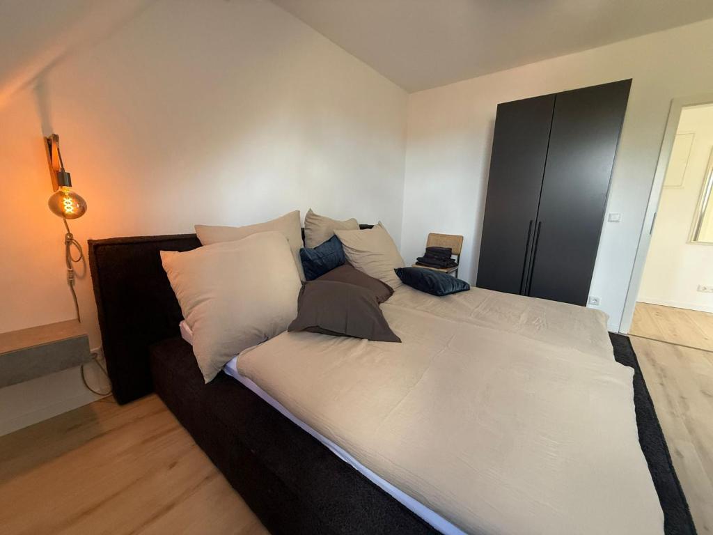 a large white bed with pillows in a bedroom at Modernes City-Apartment Mülheim - Küche, Smart-TV, schnelles WLAN, Nähe Essen & Düsseldorf in Mülheim an der Ruhr