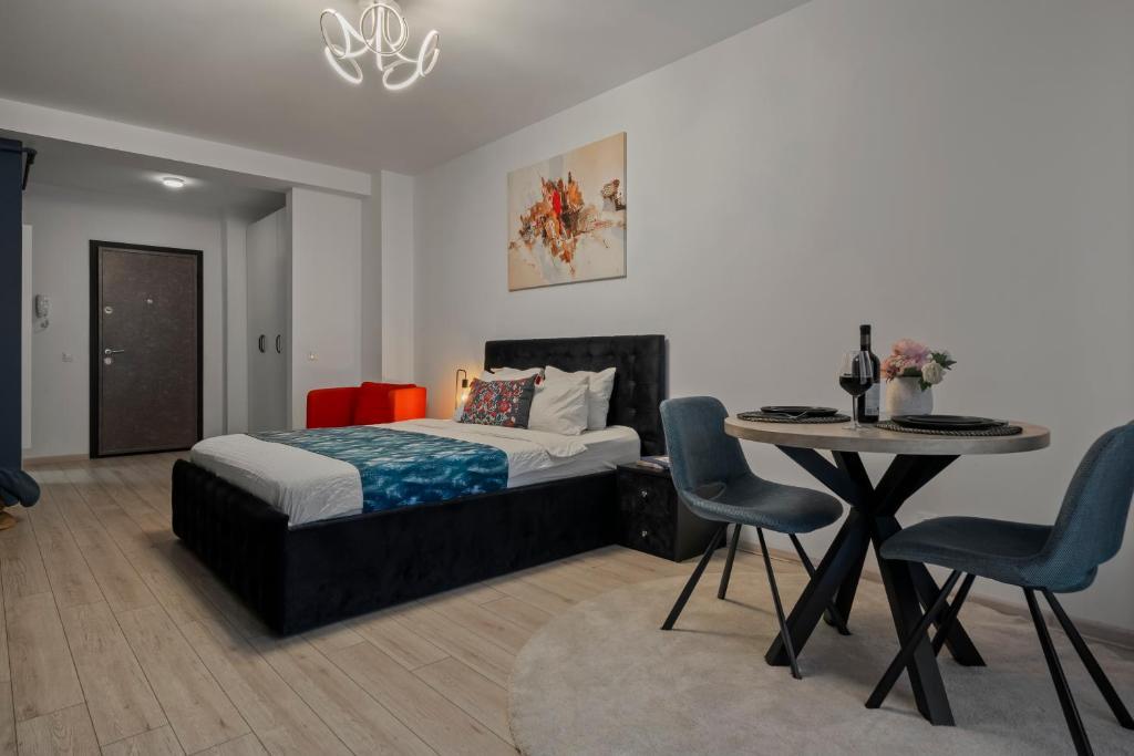 Un dormitorio con una cama y una mesa y sillas. en BlueStudio, en Bucarest