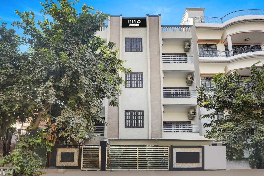 a tall white building with a sign on it at Hotel O Gol Park Atala in Prayagraj