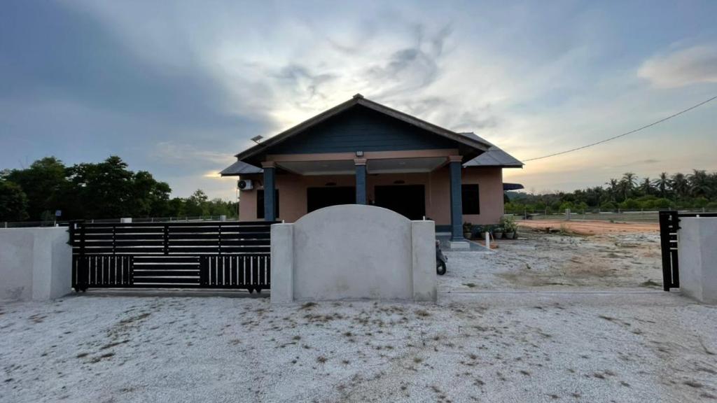 ein kleines Gebäude mit einem Tor davor in der Unterkunft Homestay setiu in Setiu