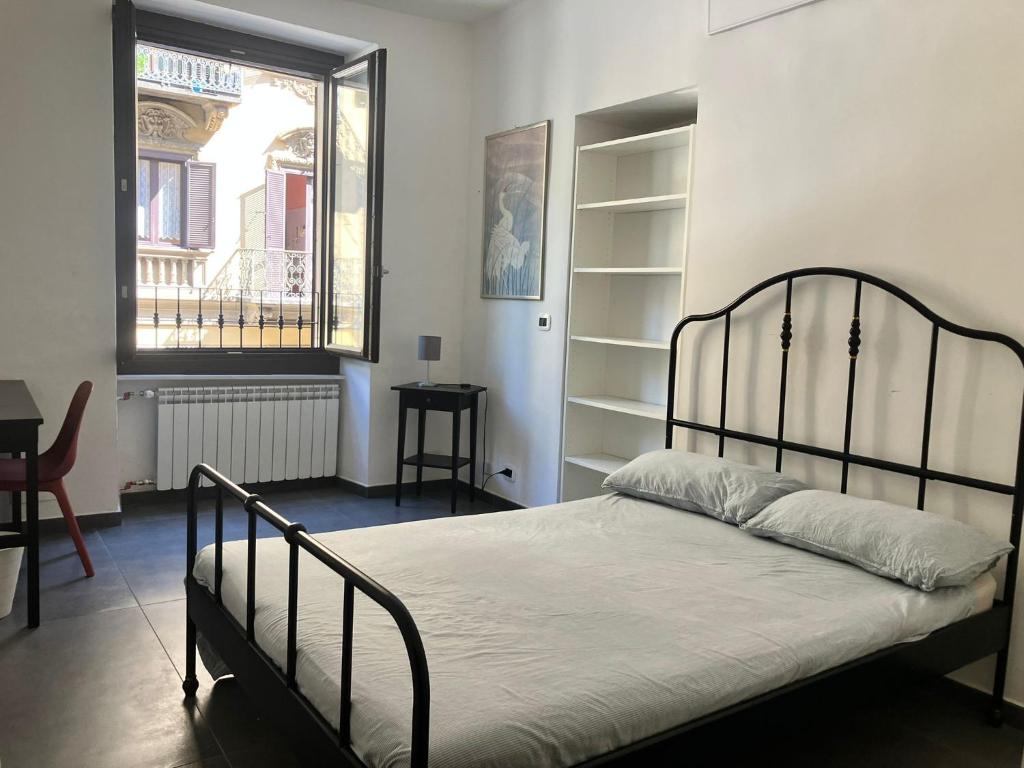 a bedroom with a bed and a window and a desk at Porta Susa Rooms in Turin