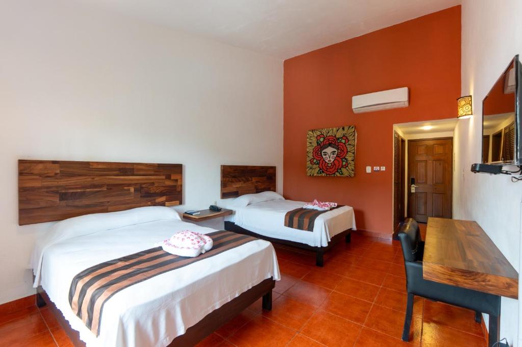 una habitación de hotel con dos camas y una mesa en Hotel Santa Cruz Huatulco, en Santa Cruz Huatulco