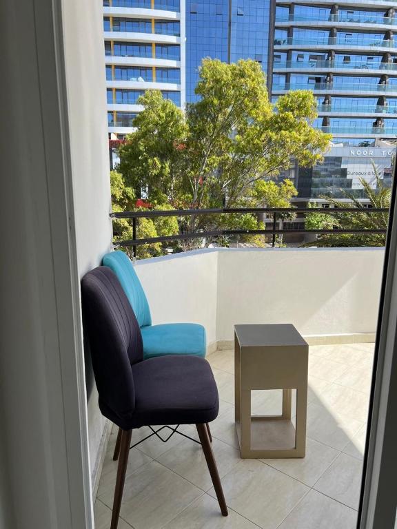 a blue chair and a table in a room with a window at corniche de Malabata in Tangier