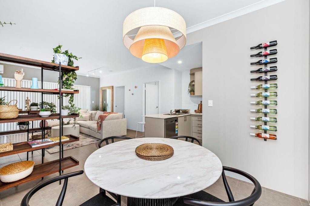 a kitchen and living room with a table and chairs at The Sepal & Swan 2BR - Ellenbrook in Henley Brook
