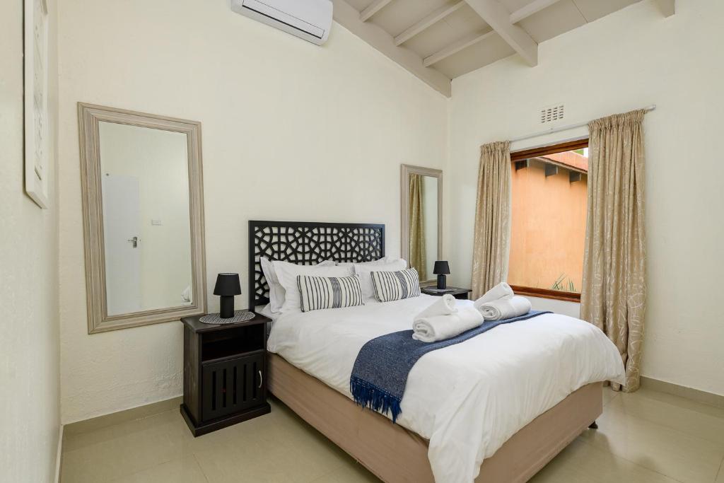 a bedroom with a large bed and a mirror at San Lameer Villa 2110 - 1 Bedroom Classic - 2 pax - San Lameer Rental Agency in Southbroom