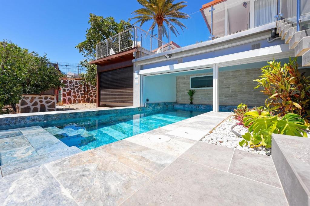 a swimming pool in the backyard of a house at Parralito by VillaGranCanaria in Ingenio