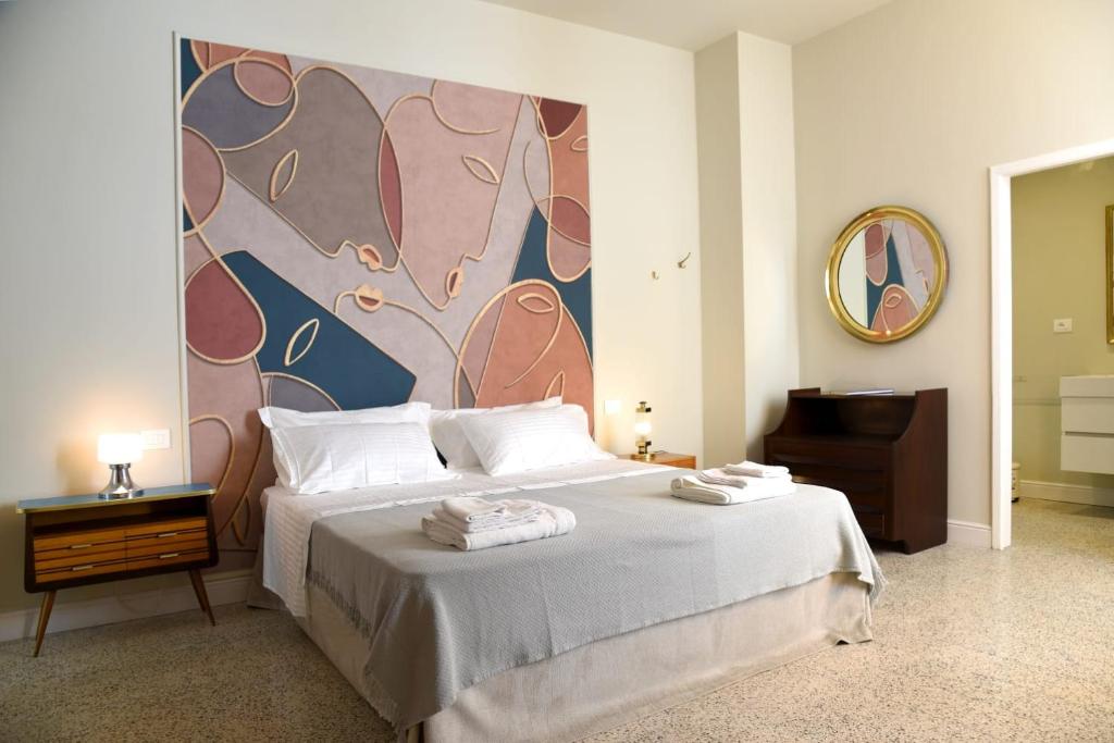 a bedroom with a bed with a painting on the wall at Dimora Sant'Allegria in Lecce