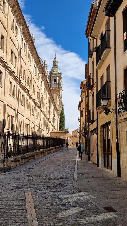 a city street with buildings and a clock tower at Serranos Salamanca Centro hasta 21plazas 6 duchas in Salamanca