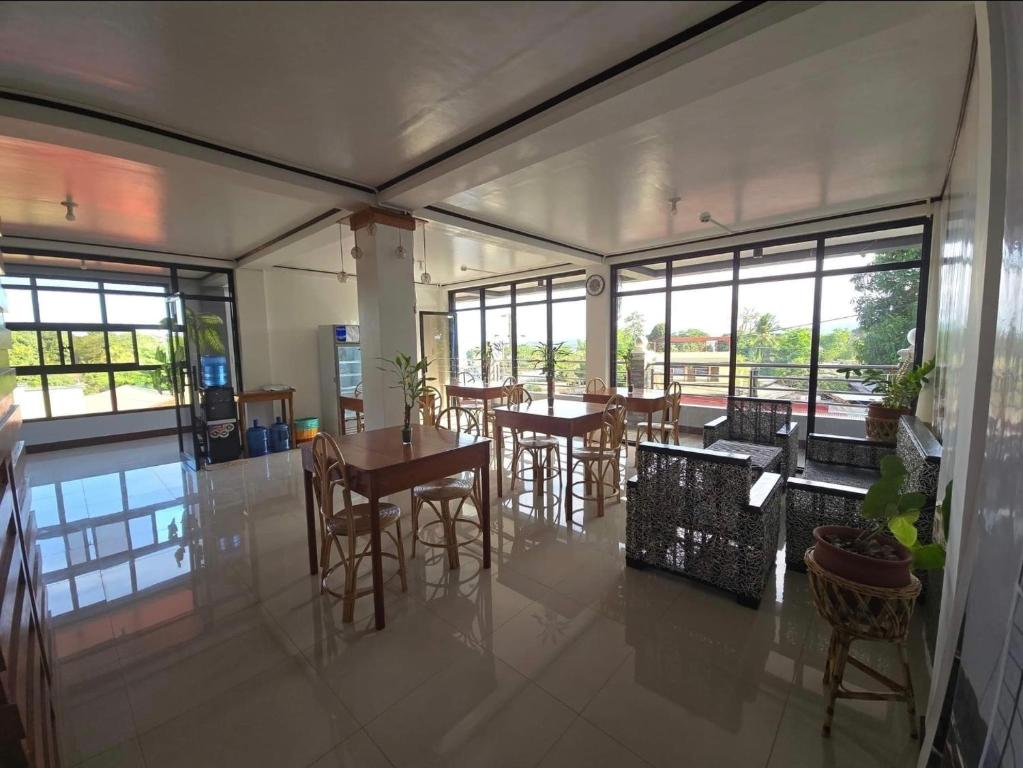 a dining room with tables and chairs and windows at NOBER Apartments in Puerto Princesa City