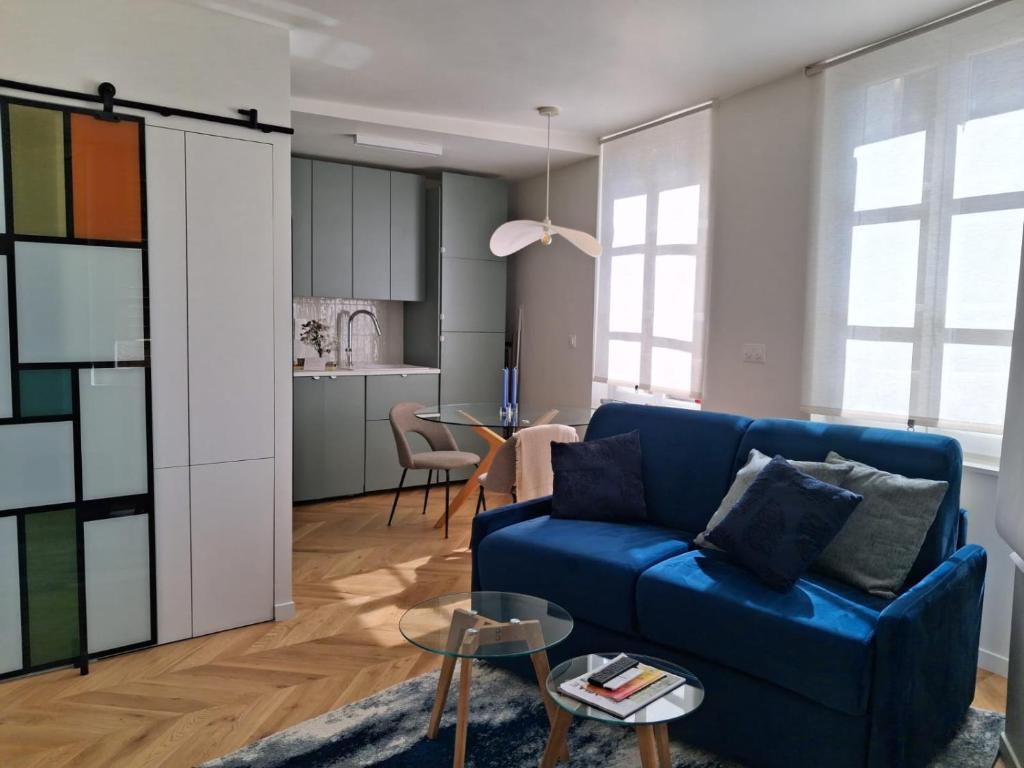 un salon avec un canapé bleu et une table dans l'établissement C'Châtelet, à Chartres