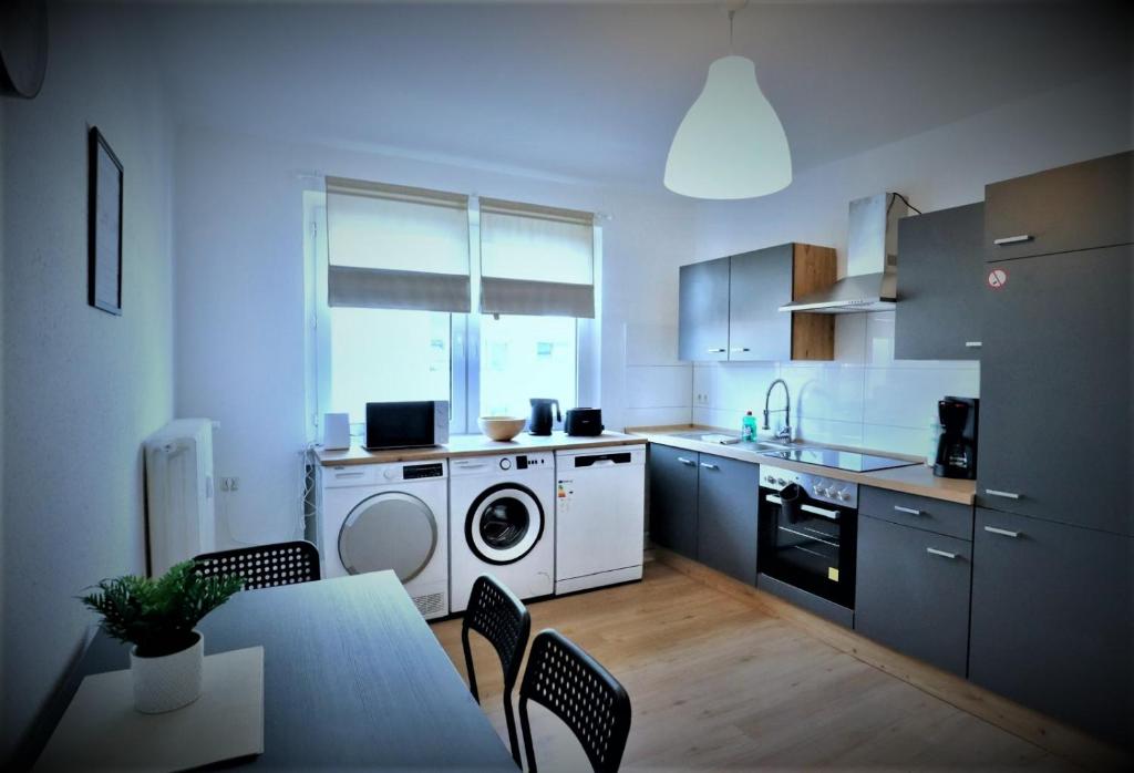 a kitchen with a washing machine and a table and chairs at Work Inn Rhein Ruhr Appartement in Duisburg