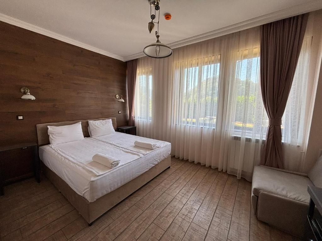 a bedroom with a bed and a large window at Villa Irina - Veliko Tarnovo in Veliko Tŭrnovo