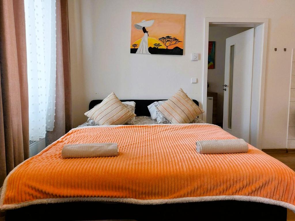 a bedroom with a bed with an orange blanket at Apartment ČSA #4 in the Historic Center Hradec Králové in Hradec Králové