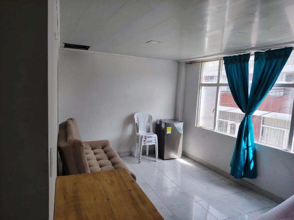 a living room with a couch and a table and a window at Encanto urbano in Moniquirá