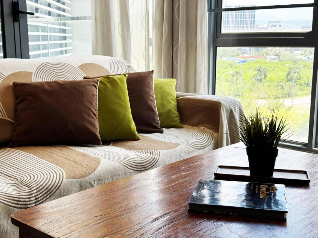 a living room with a couch and a wooden table at Imago Loft Residences - By The Pool in Kota Kinabalu