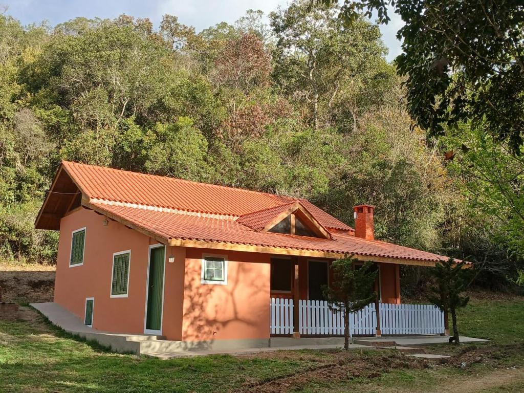 a small house with an orange roof at Pousada Refúgio do Leão in Camanducaia