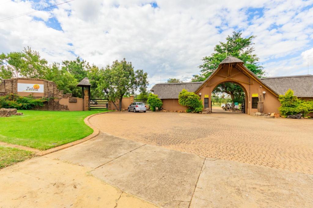 eine Kirche mit einem in der Einfahrt geparkten Auto in der Unterkunft Waterberg House at Zebula - 8 adults and 4 kids under 10 years in Mabula