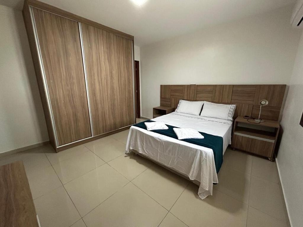 una camera da letto con un letto grande con testiera in legno di Casa por temporada trapiche Maceió Alagoas a Maceió