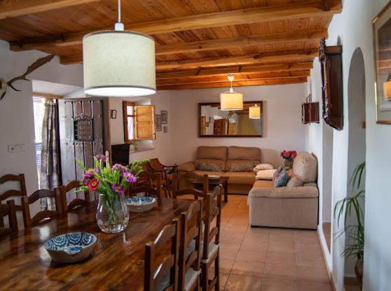 ein Wohnzimmer mit einem Tisch mit Stühlen und einer Couch in der Unterkunft CORTIJO EL PRADO l in Castril