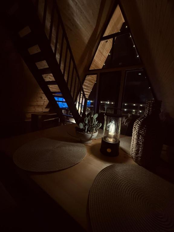 a room with a table with a candle on it at A Frame Halmeag in Hălmeag