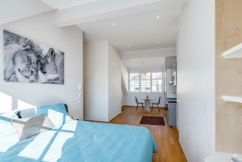 卢森堡Pétrusse Élite Suites的一间带蓝色床的卧室和一间厨房