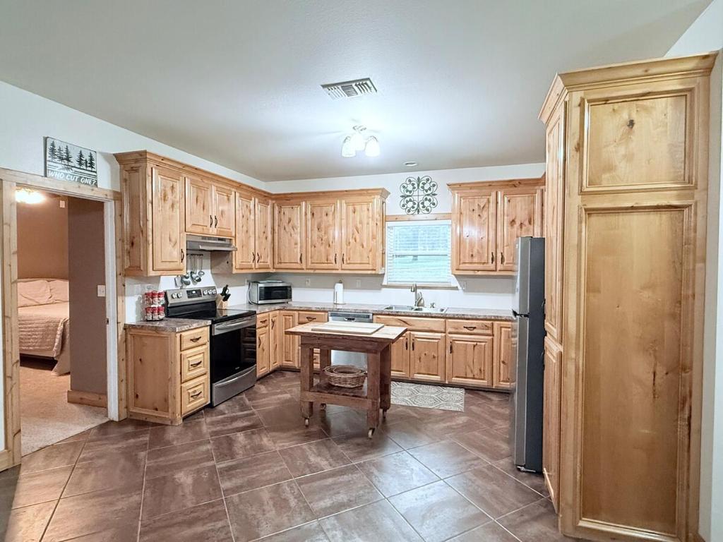 a kitchen with wooden cabinets and a table in it at Carlene's Place in Kingston