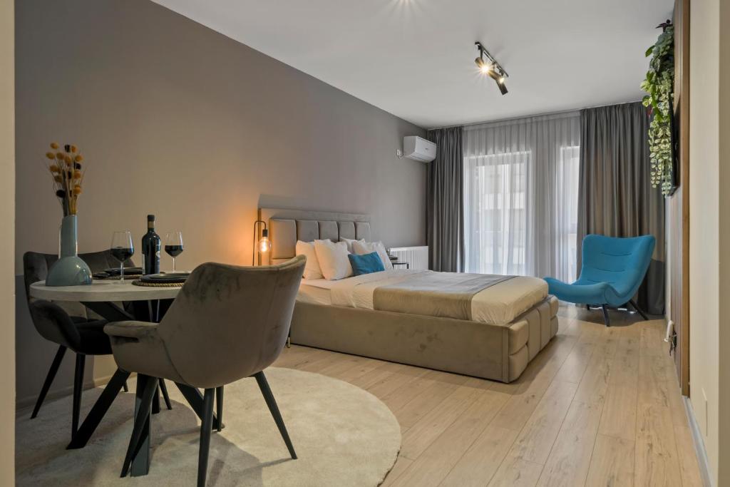 a bedroom with a bed and a table and chairs at Studio 6 in Bucharest
