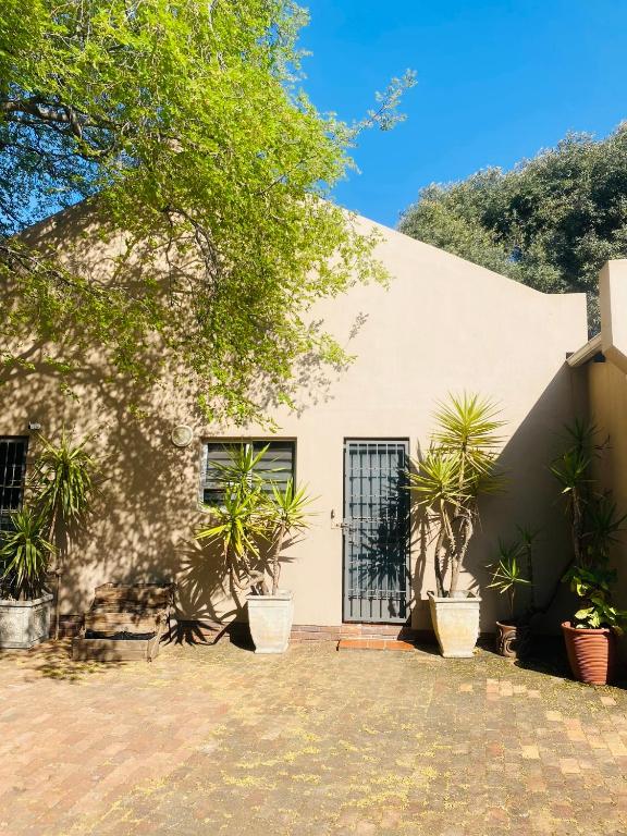 a white building with plants in front of it at House Cosy in Northriding