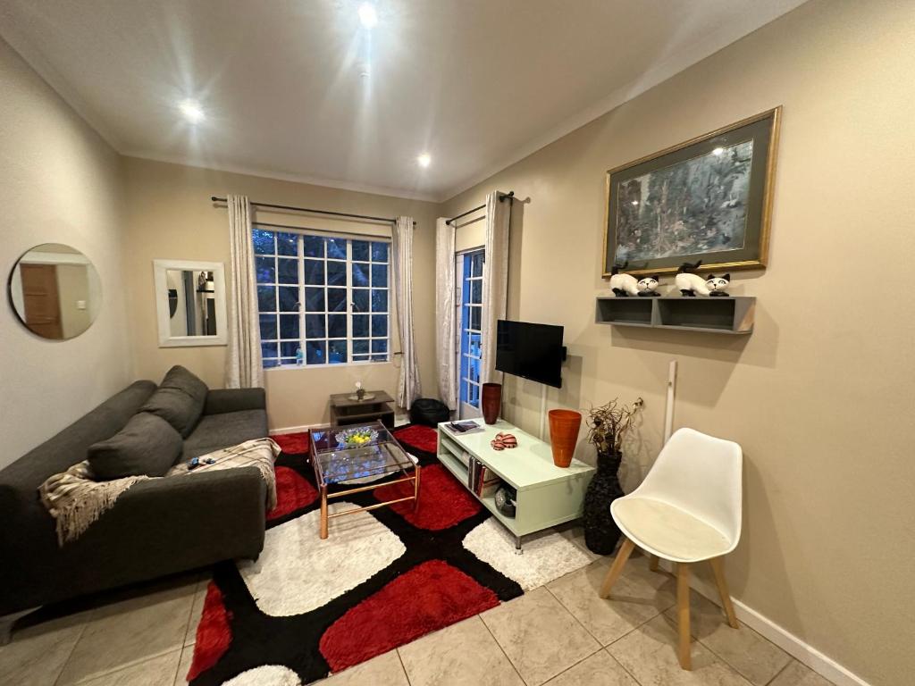 a living room with a couch and a table at Cotswold Sanctuary in Johannesburg
