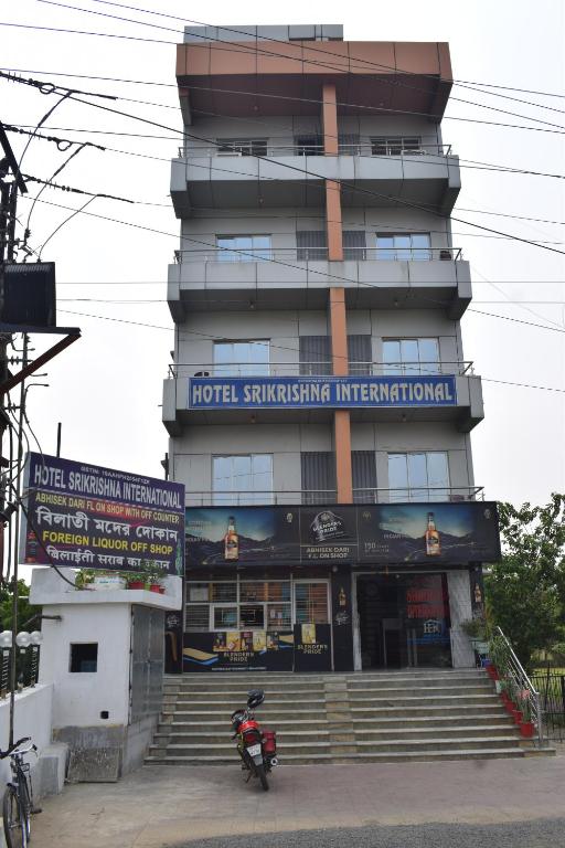 a building with a motorcycle parked in front of it at Hotel Srikrishna International in Tarapith
