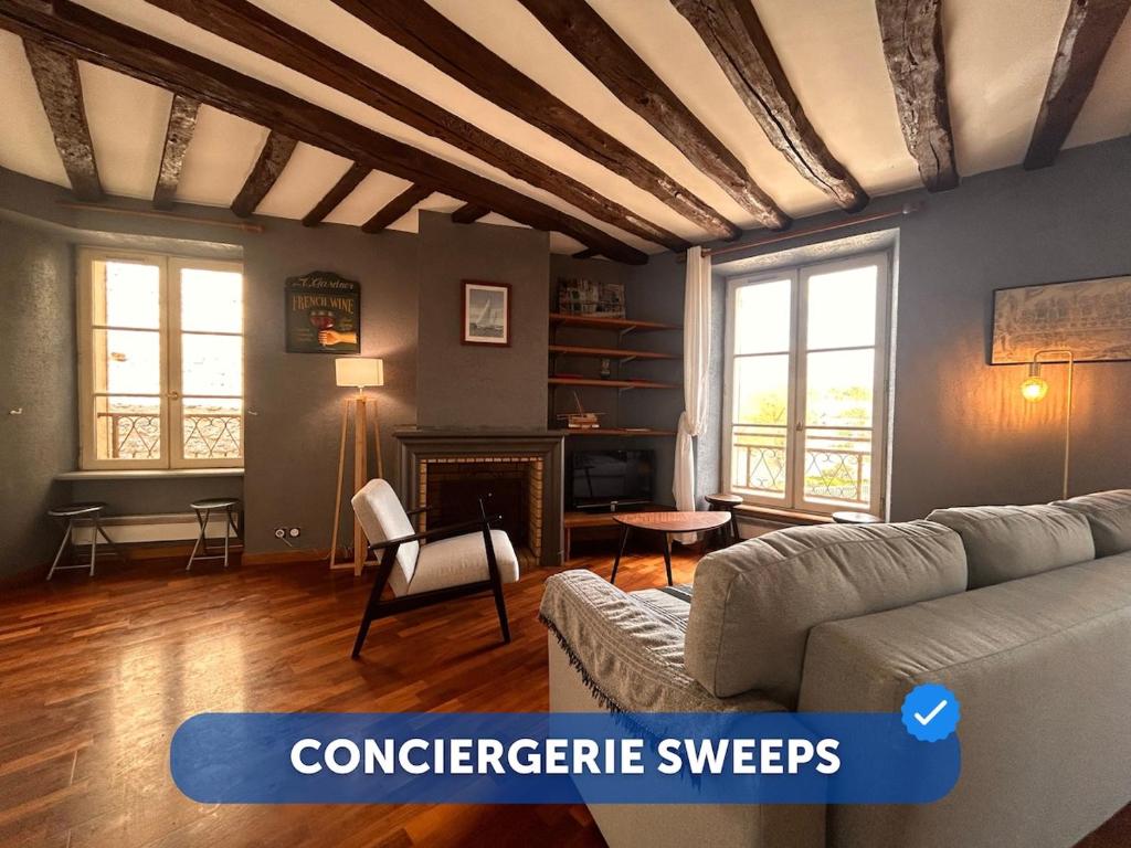 Una sala de estar con un sofá y una chimenea. en Évasion sur la rivière - 4 pers - Centre, en Moret-sur-Loing