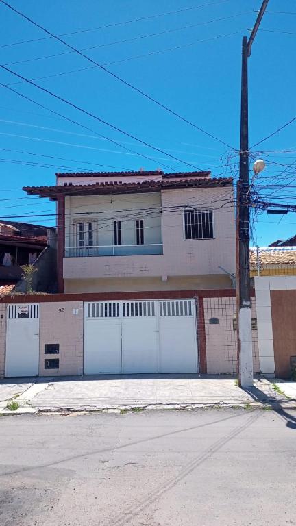 a house with two white garage doors and a street at Casas Mobiliadas Jabutiana in Aracaju