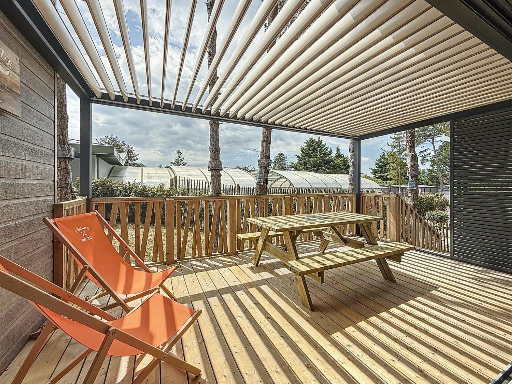 a wooden deck with a picnic table and a bench at Cottage Le Béluga in Jullouville-les-Pins