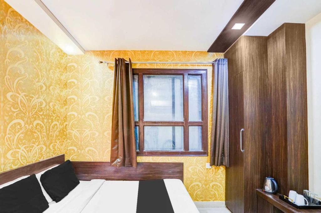 a bedroom with a bed and a window at Super Collection O Sindhi Camp Formerly Hotel Abhinandan Inn in Jaipur