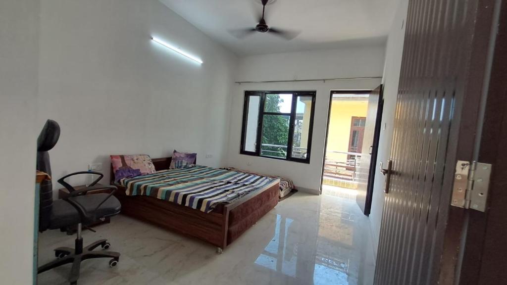 Un dormitorio con una cama y una silla dentro. en Shivang, en Jammu