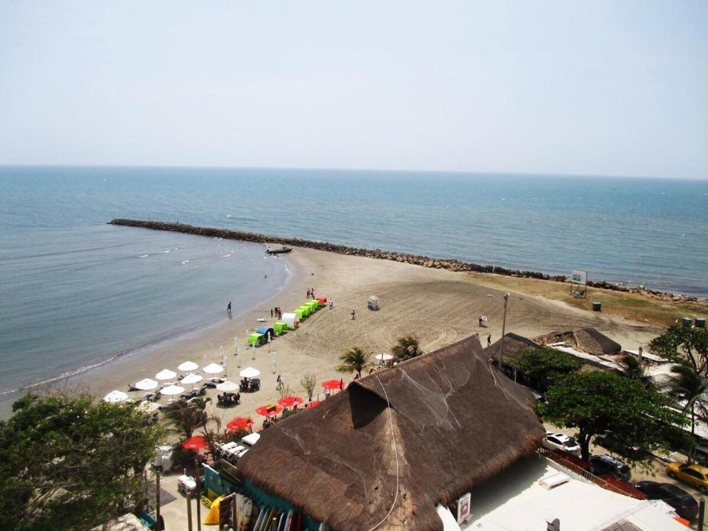 a beach with umbrellas and people on the beach at Large and beautiful Oceanfront Penthouse in Cartagena de Indias