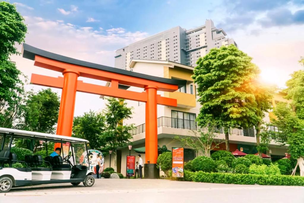 a bus parked in front of a large orange structure at Khoáng nóng Wyndham Thanh Thủy Onsen in La Phu