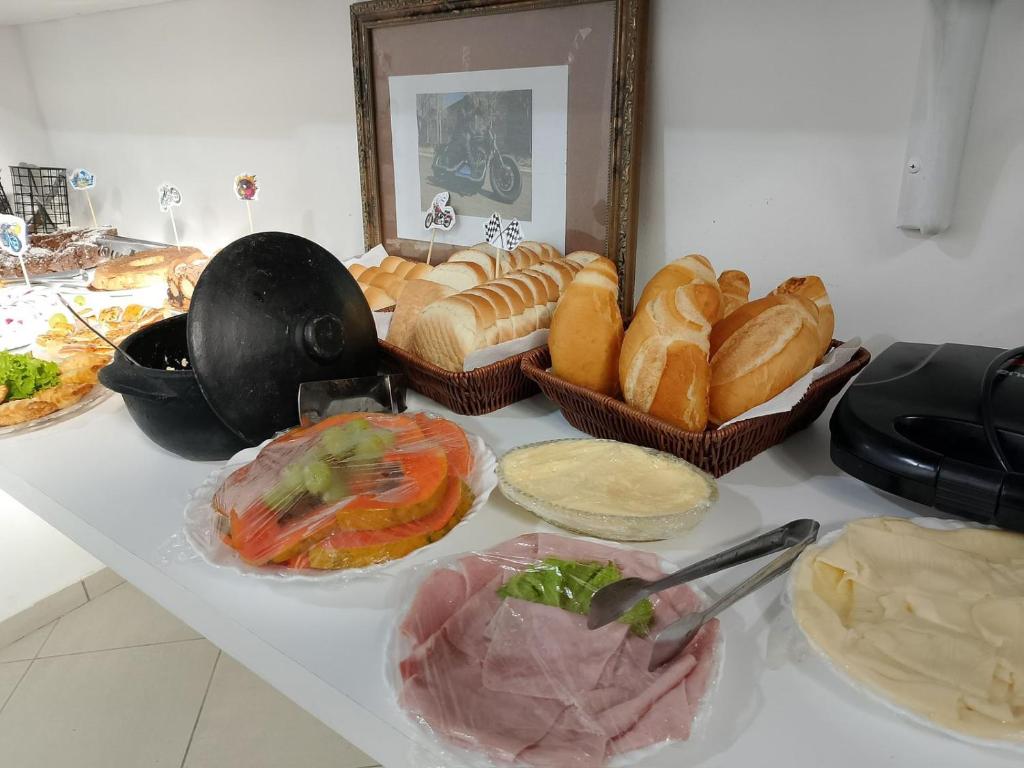 a table topped with baskets of bread and pastries at Pousada Costa Mar in Rio das Ostras