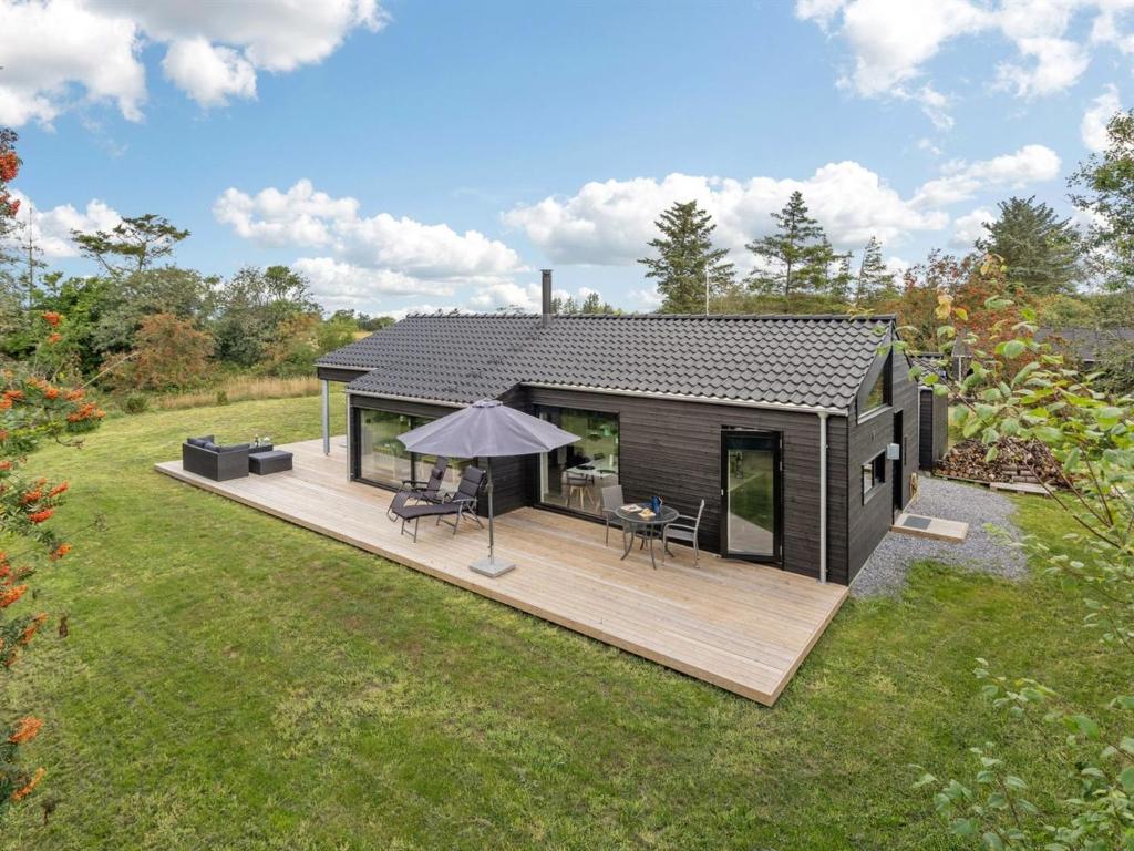 una piccola cabina con terrazza in legno in un campo di Holiday Home Hildegard - 1-5km from the sea by Interhome a Hjørring