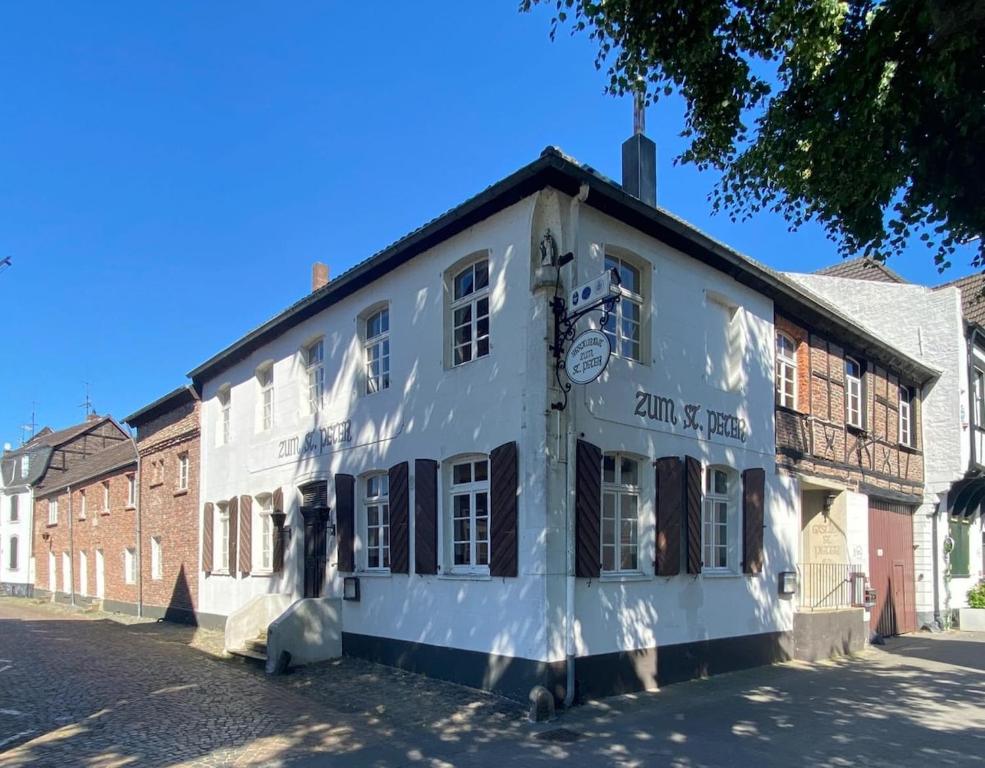 a white building on the side of a street at Zu Gast im Denkmal St Peter in Dormagen