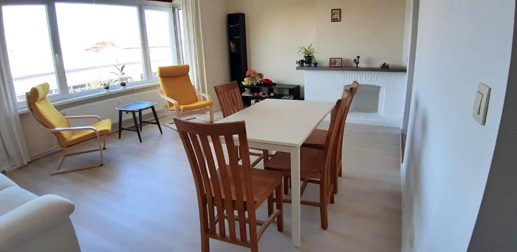Un comedor con mesa y sillas y una cocina. en Miss Cato, en Ostende