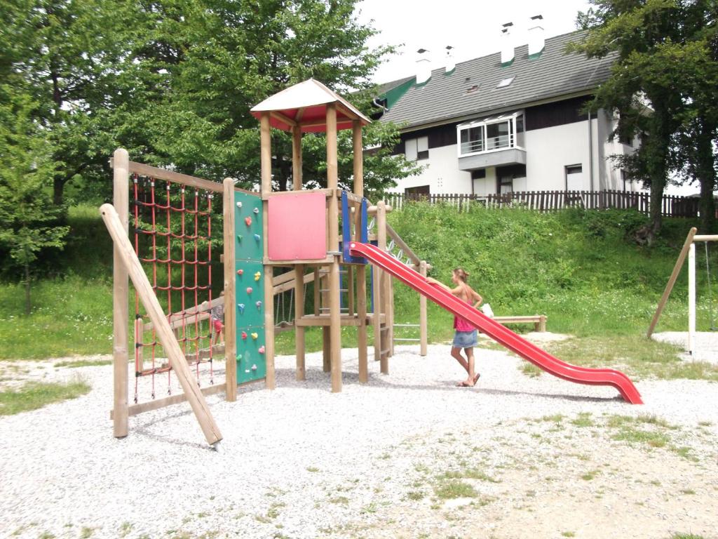 a couple of kids playing on a playground at Art Apartman in Plitvička Jezera